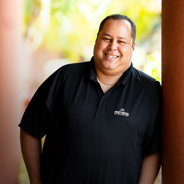 Luis Burelli stands in a park in Sarasota, near the First Watch location he manages