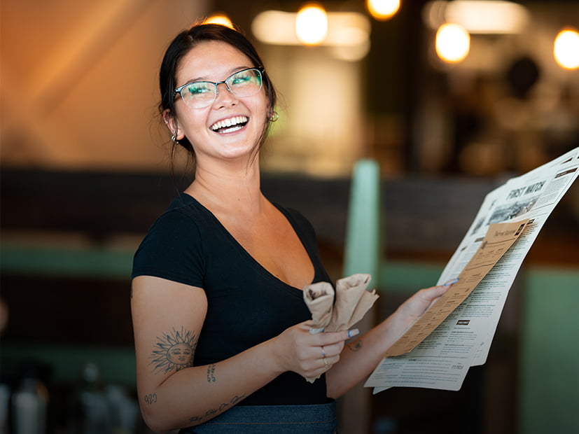 Server smiles as she walks guests to their table